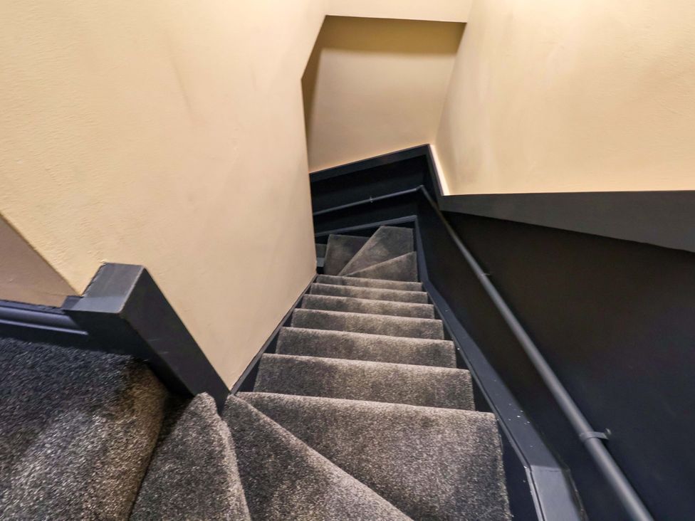 A staircase with grey carpeting at G's Loft in Whitby