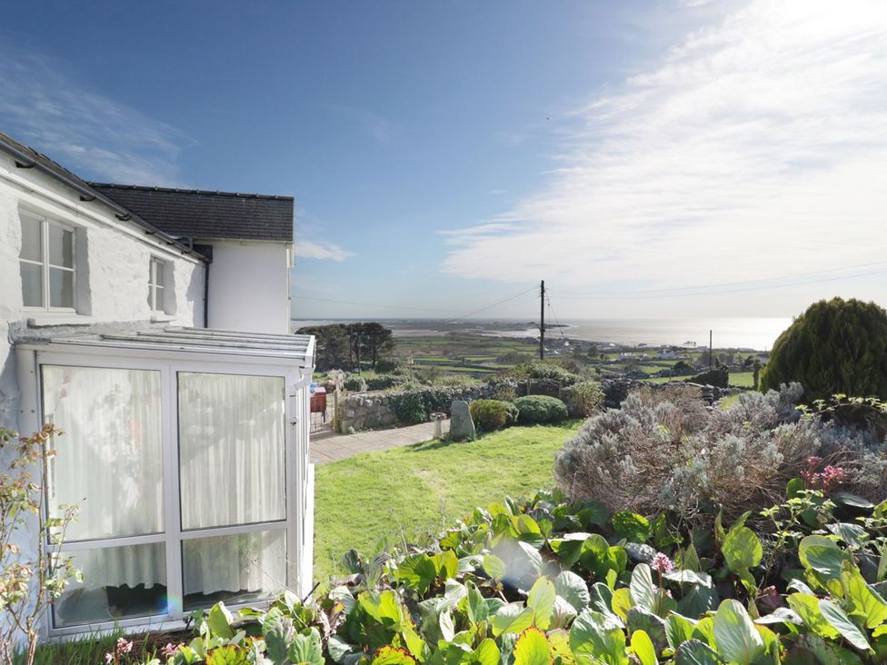 A garden with a house and a view overlooking the landscape at Happy Landing in Harlech