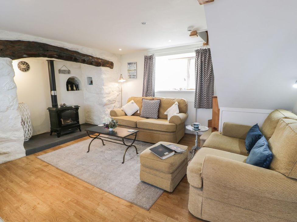 A living room with sofas and a stove at Happy Landing in Harlech