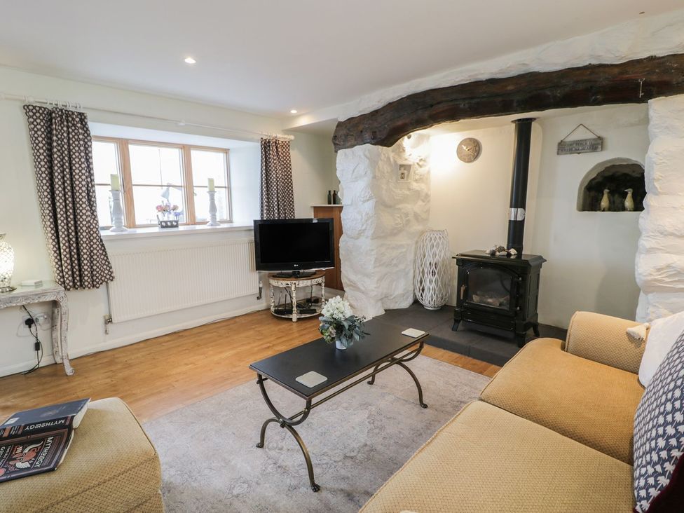 A living room with a fireplace and a television at Happy Landing in Harlech