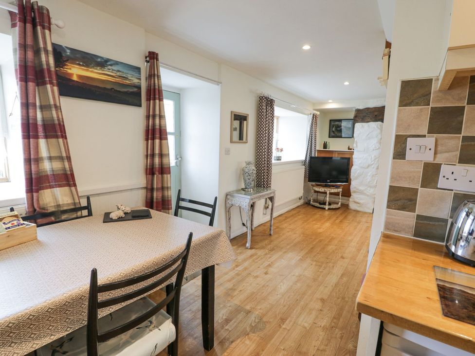 A dining area with a table and chairs at Happy Landing in Harlech