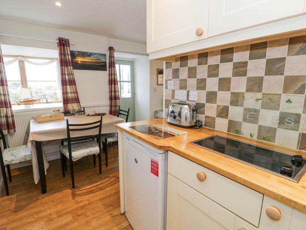 A kitchen with a table and chairs at Happy Landing in Harlech