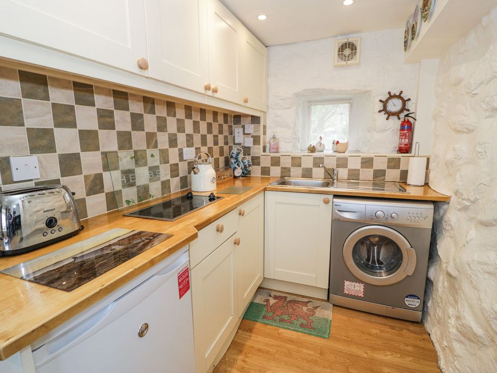 A kitchen with a washing machine and toaster at Happy Landing in Harlech