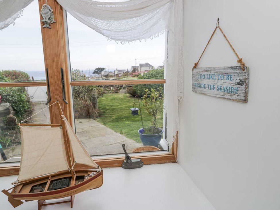 A view with a model sailboat and seaside sign at Happy Landing in Harlech