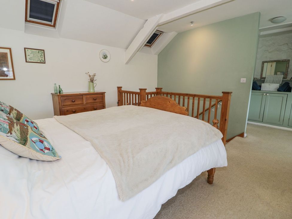 A bedroom with a bed and dresser at Happy Landing in Harlech