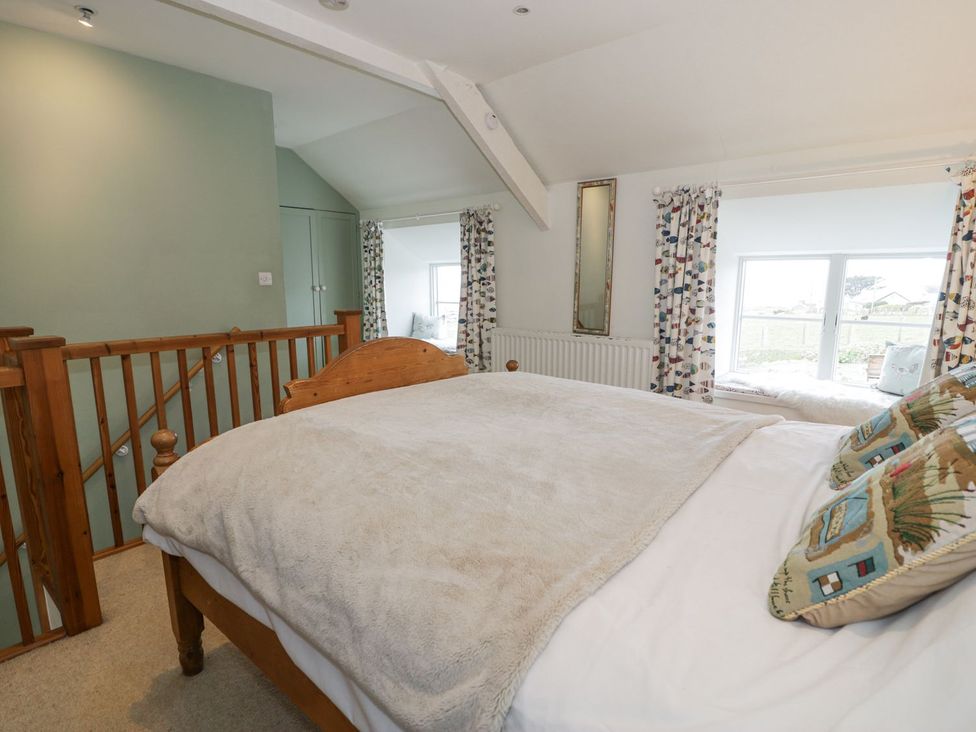 A bedroom with a bed and curtains at Happy Landing in Harlech