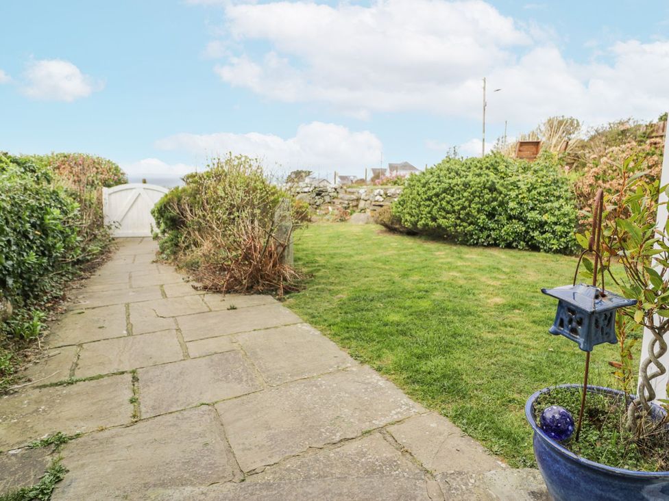 A garden with a stone pathway and plants at Happy Landing in Harlech