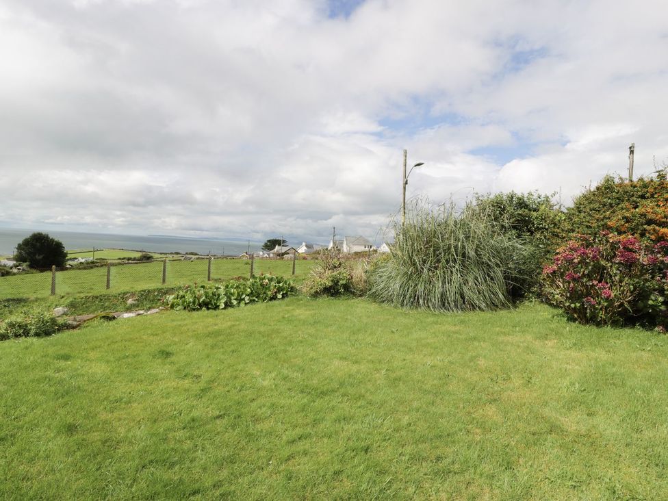 A garden with grass and plants at Happy Landing in Harlech