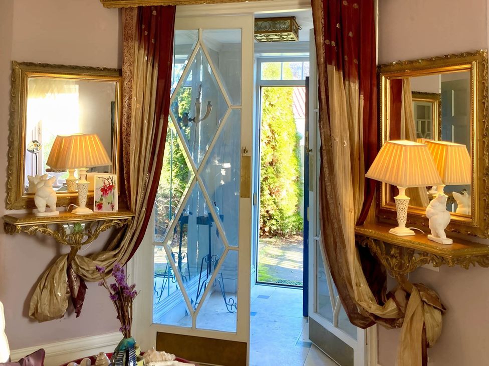 A room with mirrors, lamps, and decorative items at Groves Hall Garden Apartment Whitby