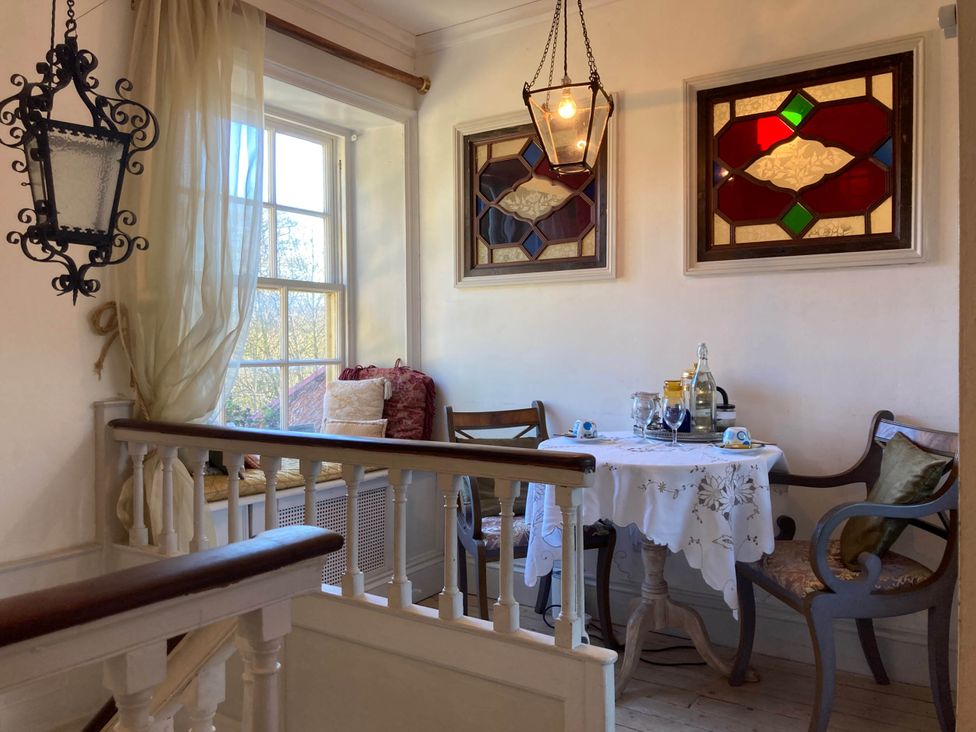 A dining area with a table and chairs at Groves Hall Garden Apartment Whitby