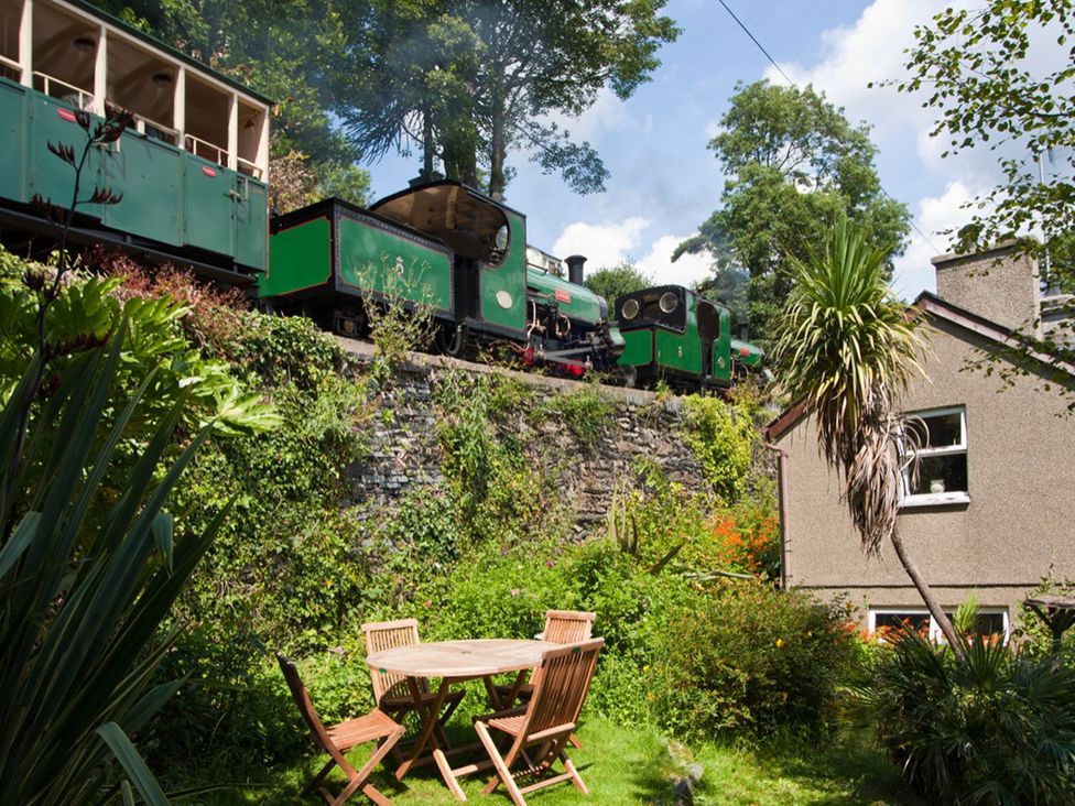 A garden with a table and chairs at Bodorwel Cottage in Penrhyndeudraeth