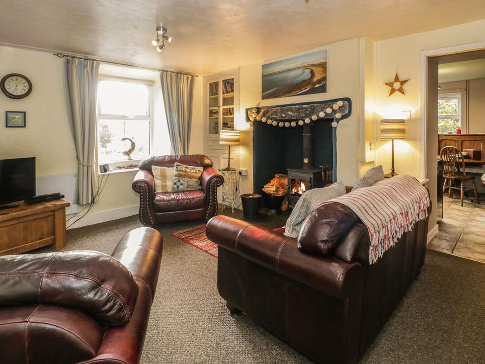 A living room with a fireplace and sofa at Bodorwel Cottage in Penrhyndeudraeth