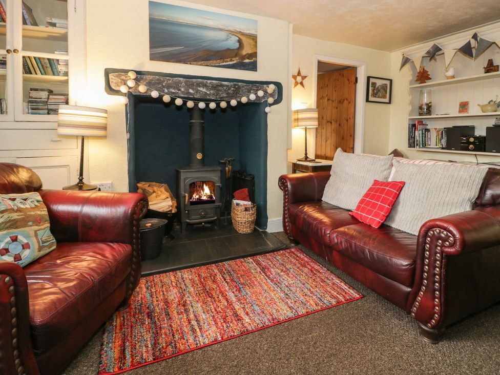 A living room with a fireplace and sofas at Bodorwel Cottage in Penrhyndeudraeth