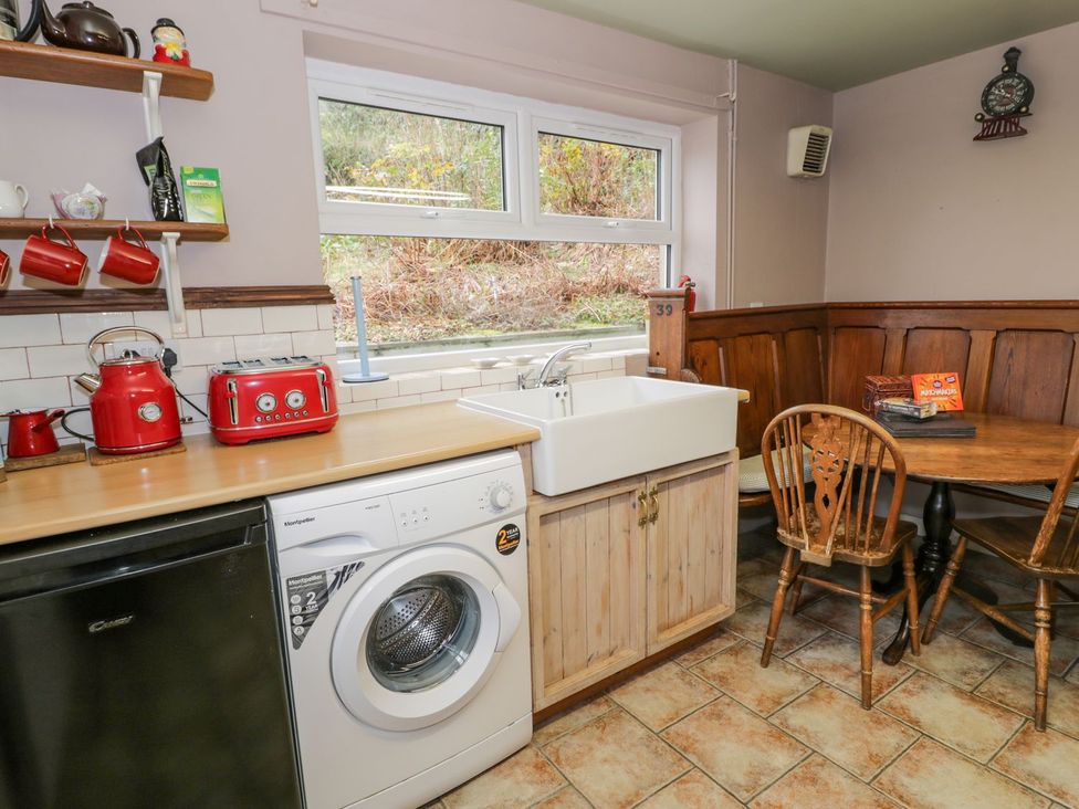 A kitchen with a washing machine and sink at Bodorwel Cottage in Penrhyndeudraeth