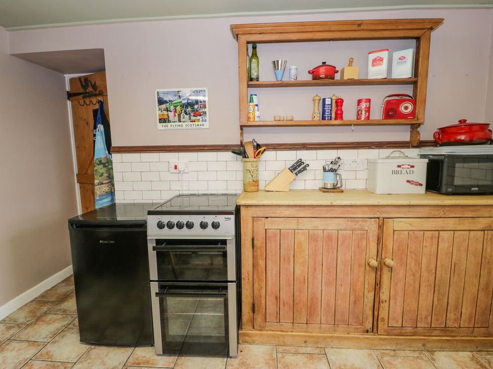 A kitchen with appliances and storage at Bodorwel Cottage Penrhyndeudraeth