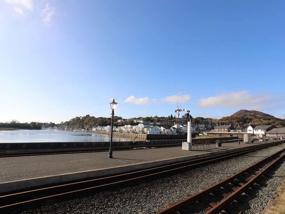 A coastal view with railway tracks and buildings at Bodorwel Cottage Penrhyndeudraeth
