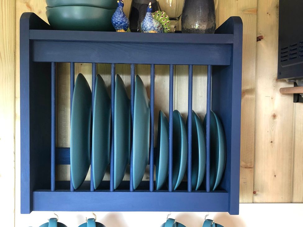 Shelves displaying plates and mugs at The Peacock Shepherds Hut at Hafoty Boeth, Corwen