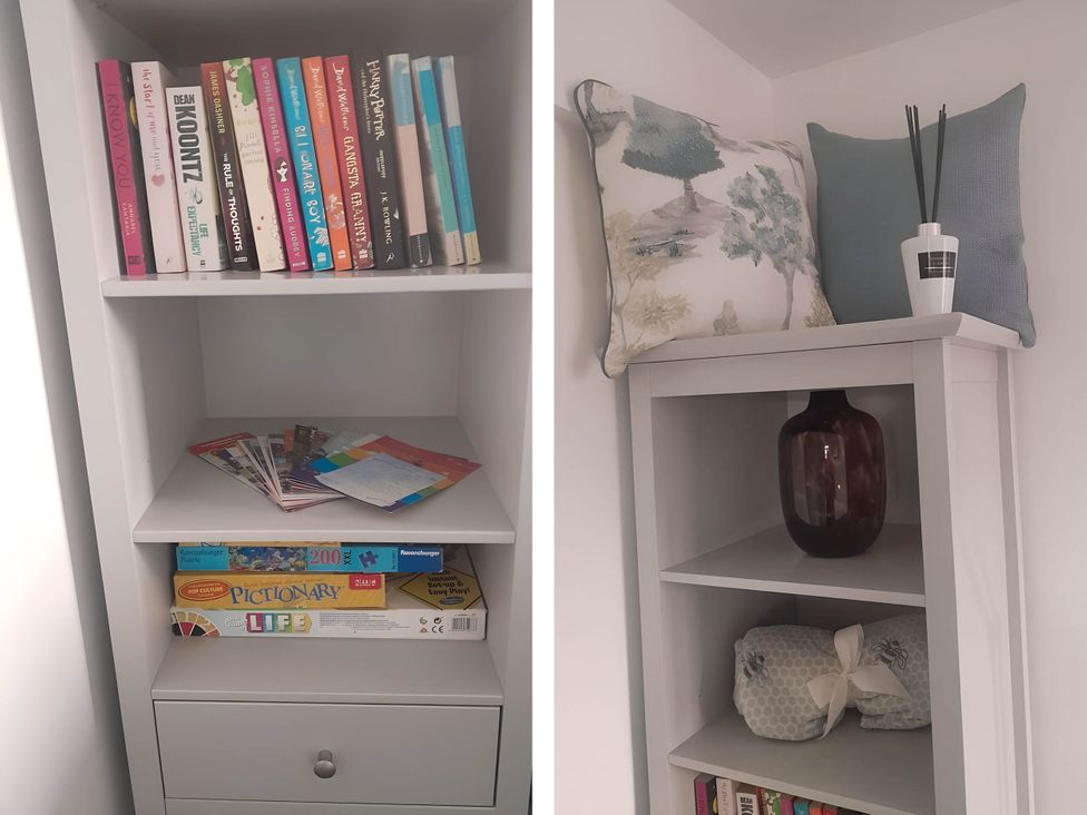 A shelf with books and games at 1-Bed House, Sleeps 4, Free Parking