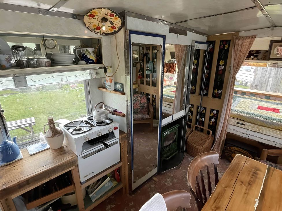 A kitchen with a stove, sink, and table at 2 x Double Bed Glamping Wagon at Dalby Forest, Scarborough