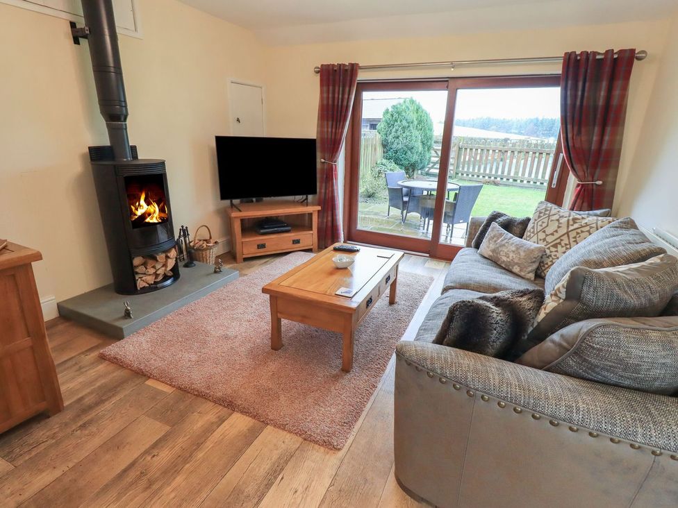 A living room with a wood stove and sofa at Orcaber Farm Retreat in Lancaster