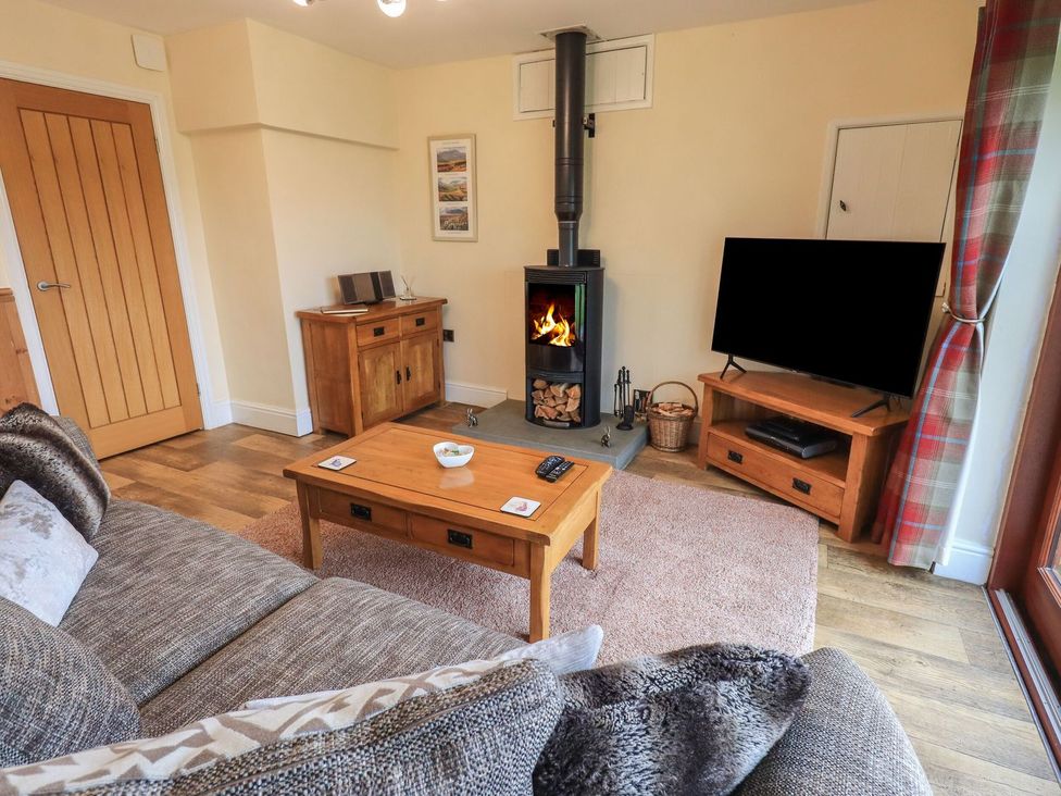 A living room with a wood stove and television at Orcaber Farm Retreat in Lancaster