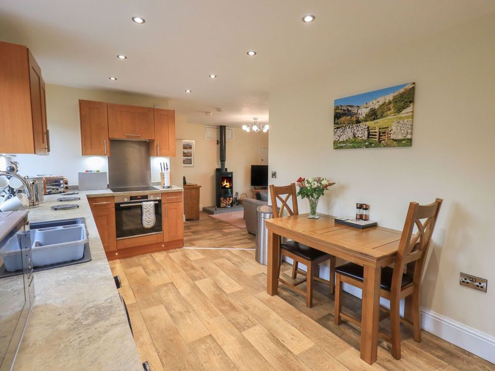 A kitchen with wooden cabinets and table at Orcaber Farm Retreat in Lancaster