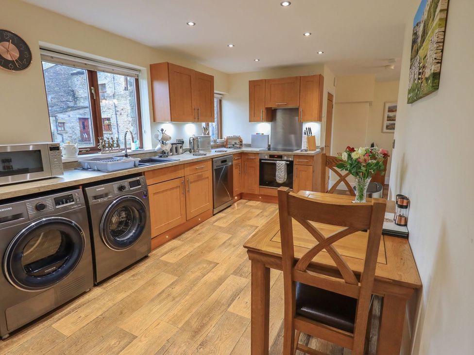 A kitchen with appliances and a dining table at Orcaber Farm Retreat in Lancaster