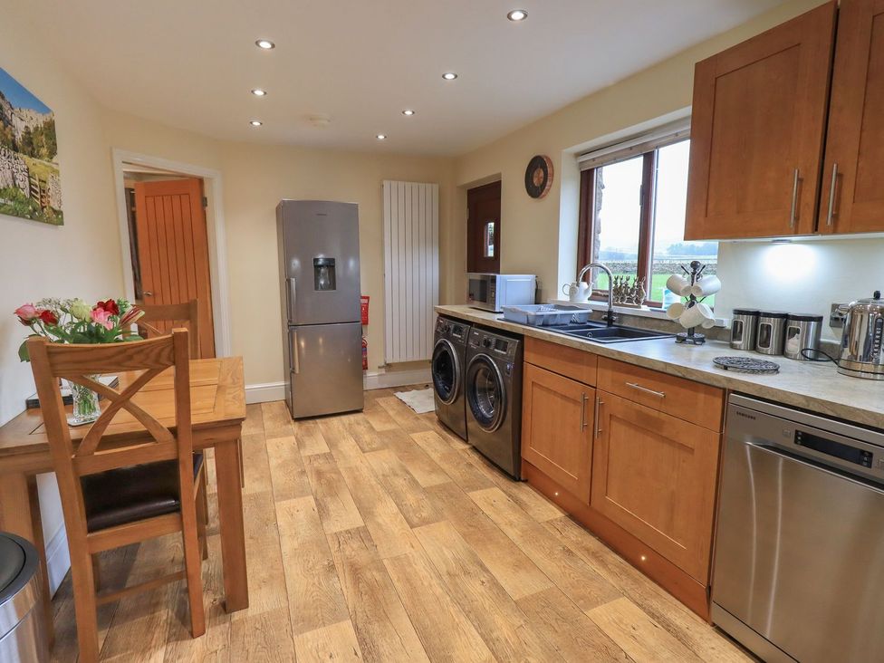A kitchen with appliances and a dining table at Orcaber Farm Retreat in Lancaster