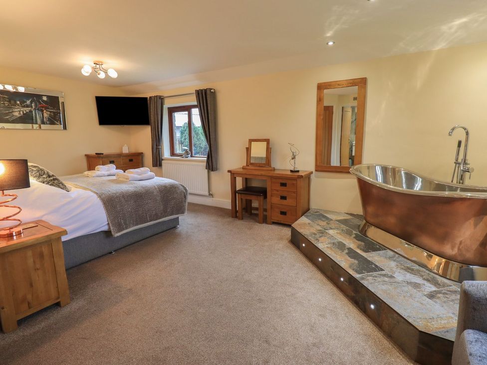 A bedroom with a bed, television, and bathtub at Orcaber Farm Retreat in Lancaster