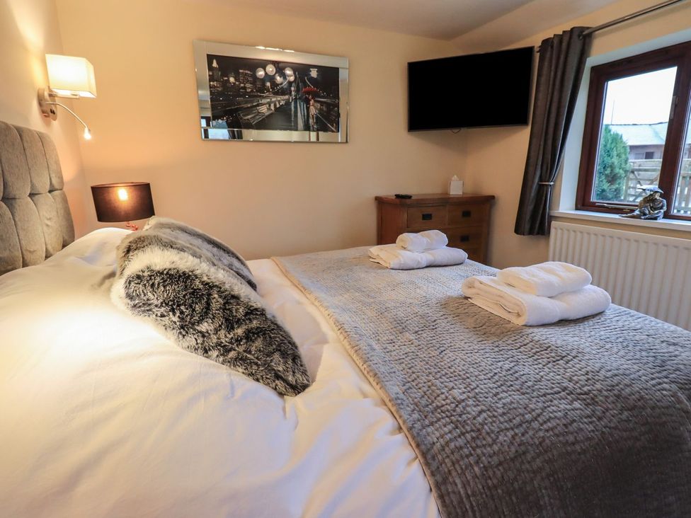 A bedroom with a bed and television at Orcaber Farm Retreat in Lancaster