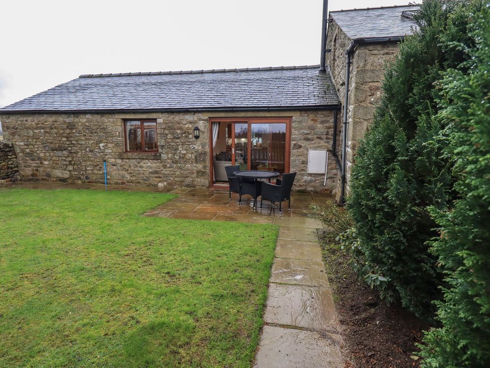 A garden with a stone wall and outdoor seating at Orcaber Farm Retreat in Lancaster