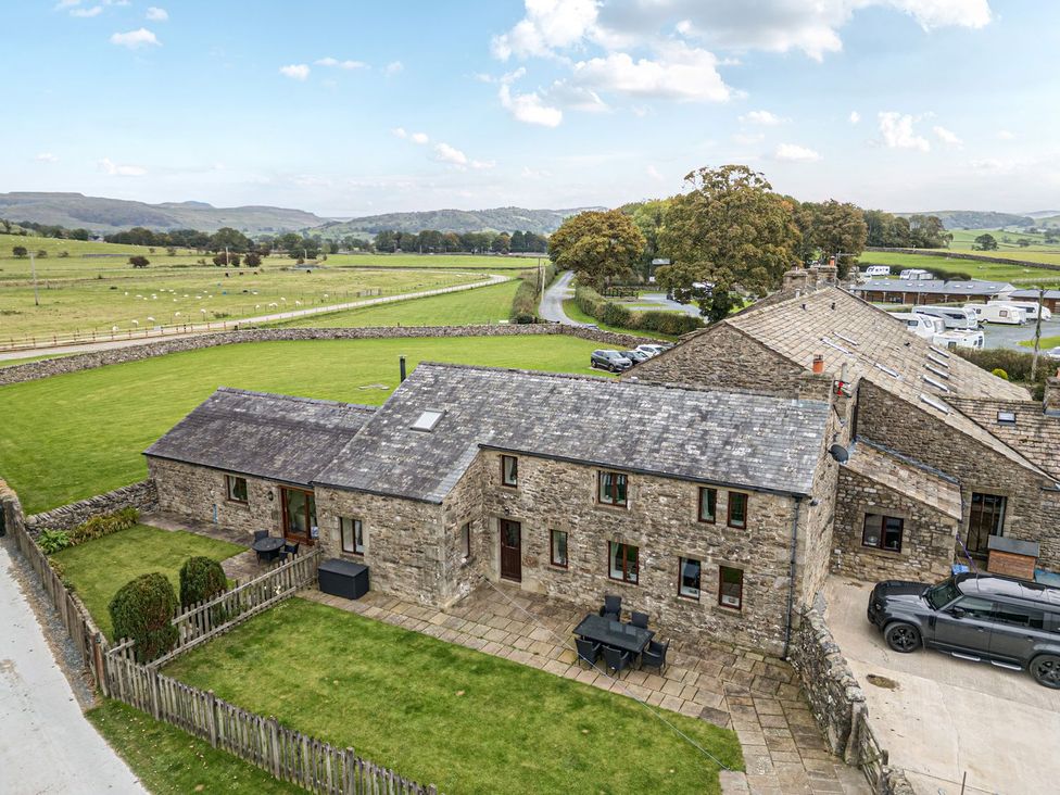 An outdoor view of a stone house with a patio and grass at Orcaber Farm Retreat in Lancaster