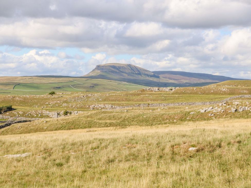 A mountain in the background with fields and rocks in the foreground at Orcaber Farm Retreat in Lancaster