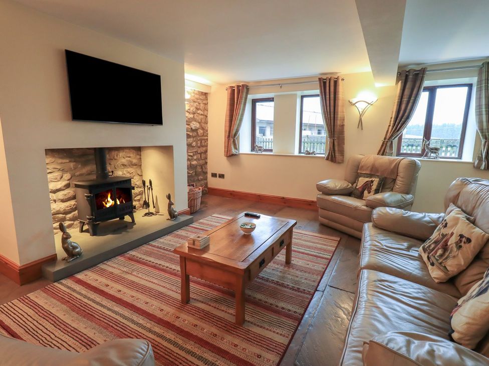A living room with a fireplace and seating at Orcaber Farm Barn in Lancaster