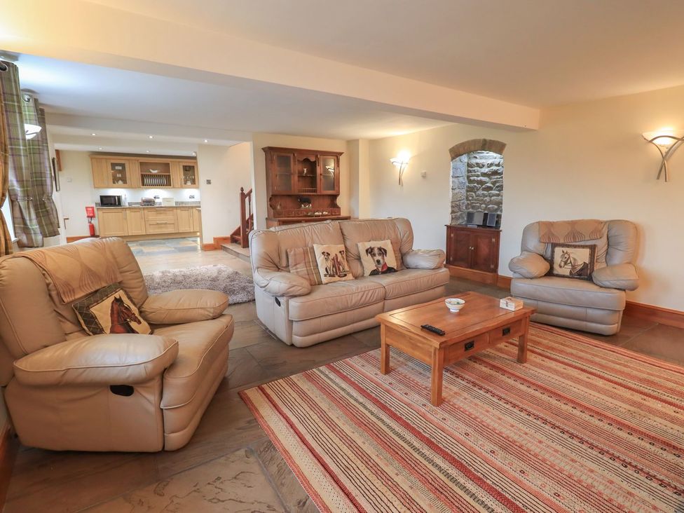 A living room with a sofa and coffee table at Orcaber Farm Barn in Lancaster