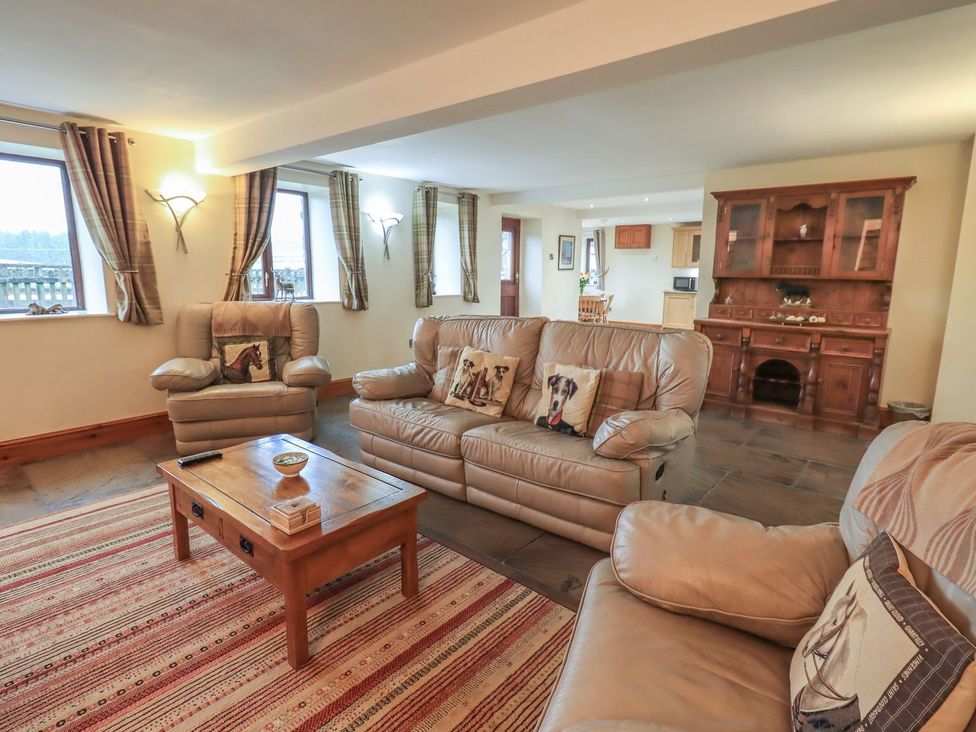 A living room with sofas and a coffee table at Orcaber Farm Barn in Lancaster