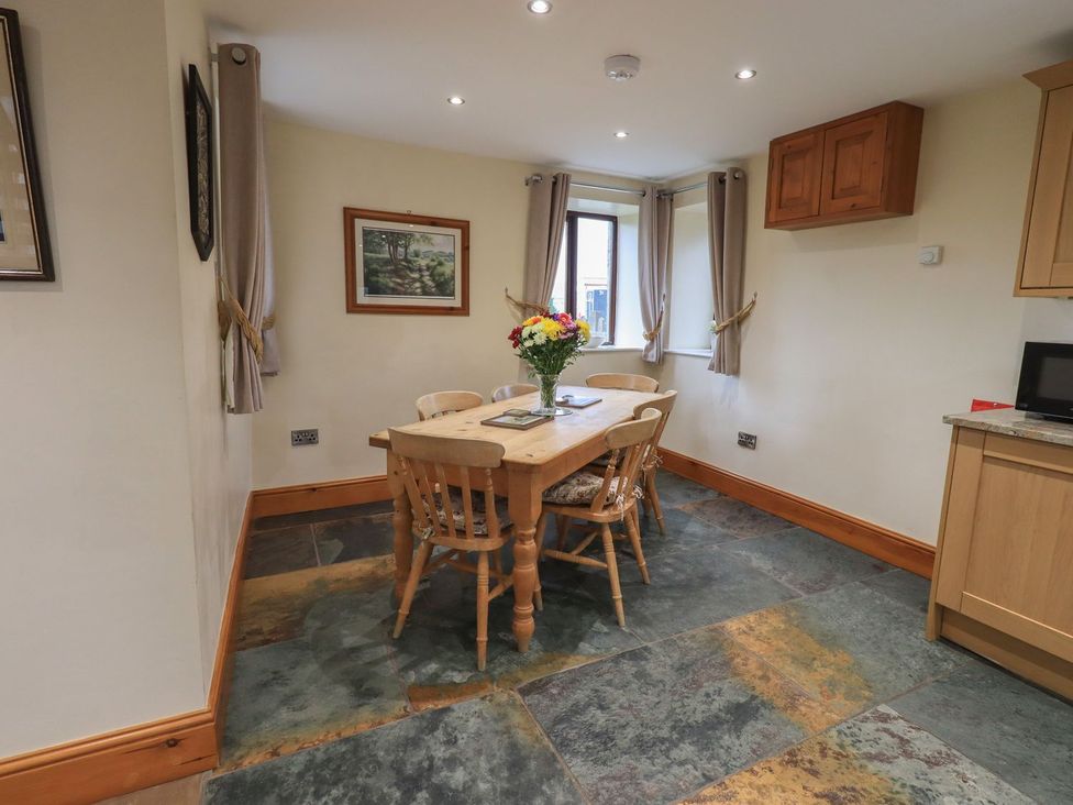A dining room with a table and chairs at Orcaber Farm Barn in Lancaster