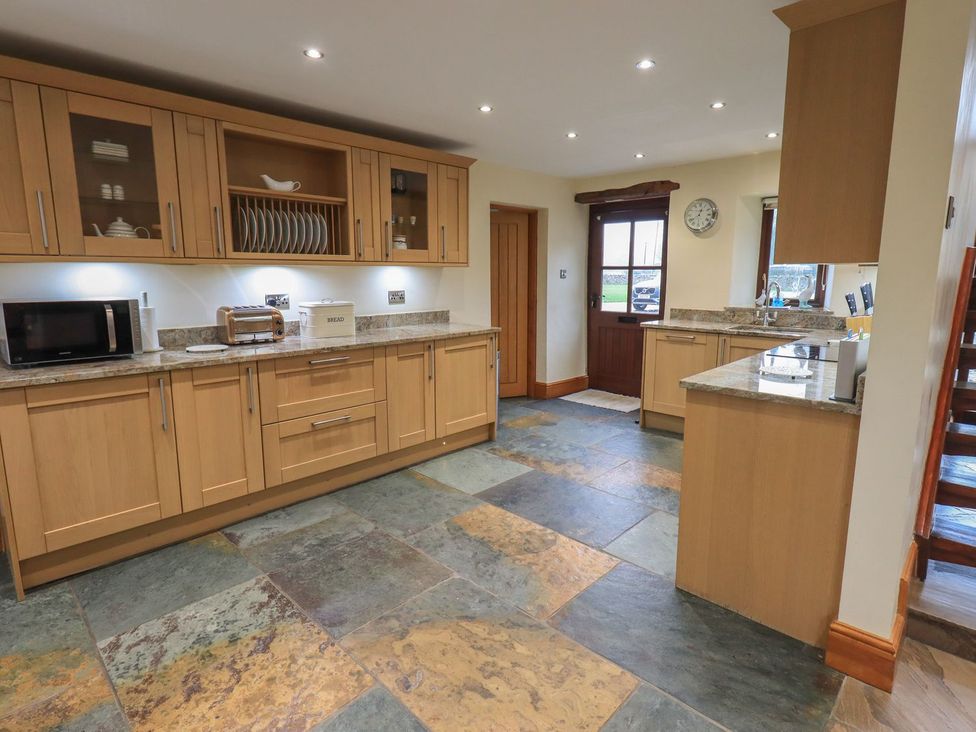 A kitchen with cabinets, countertop, sink, and appliances at Orcaber Farm Barn in Lancaster