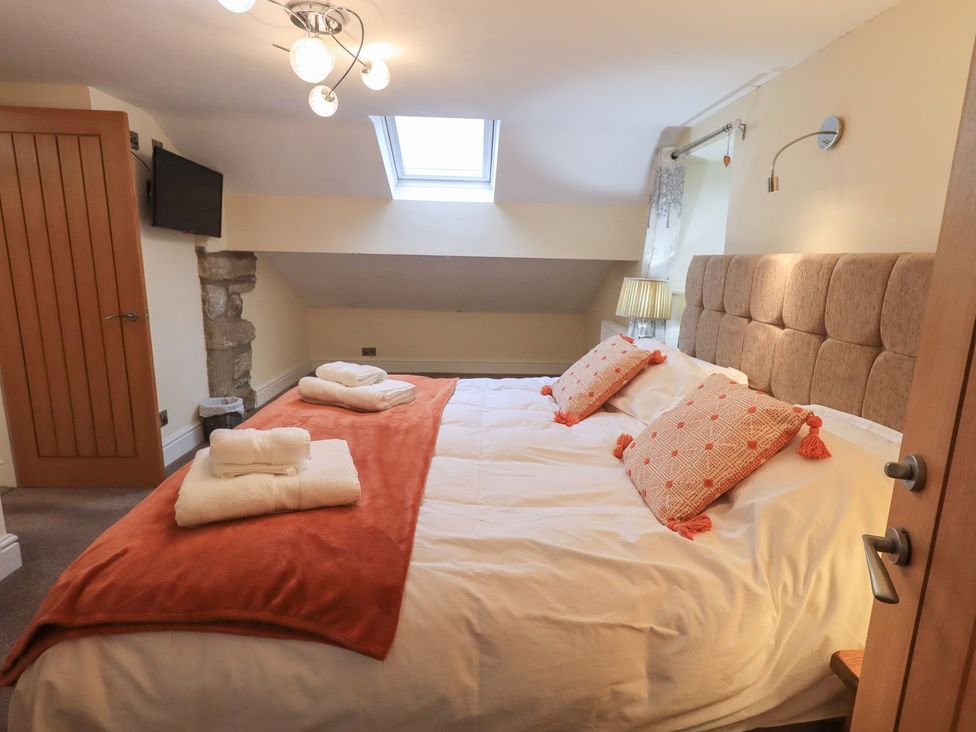 A bedroom with a double bed and television at Orcaber Farm Barn in Lancaster