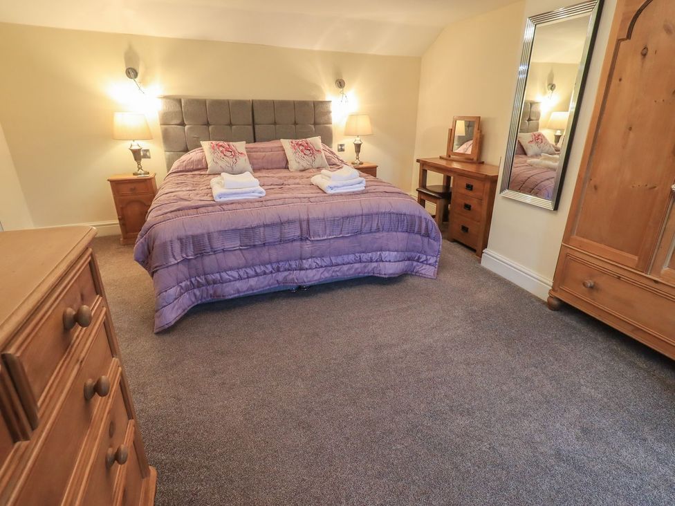 A bedroom with a bed and furniture at Orcaber Farm Barn in Lancaster