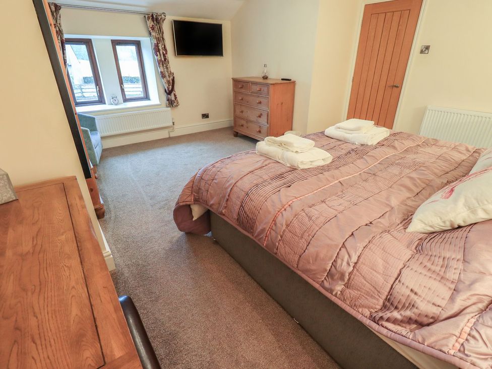 A bedroom with a bed and dresser at Orcaber Farm Barn in Lancaster
