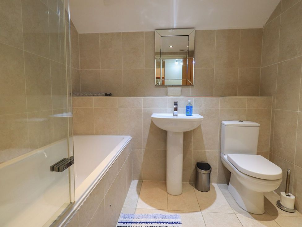 A bathroom with a bathtub, toilet, and sink at Orcaber Farm Barn Lancaster