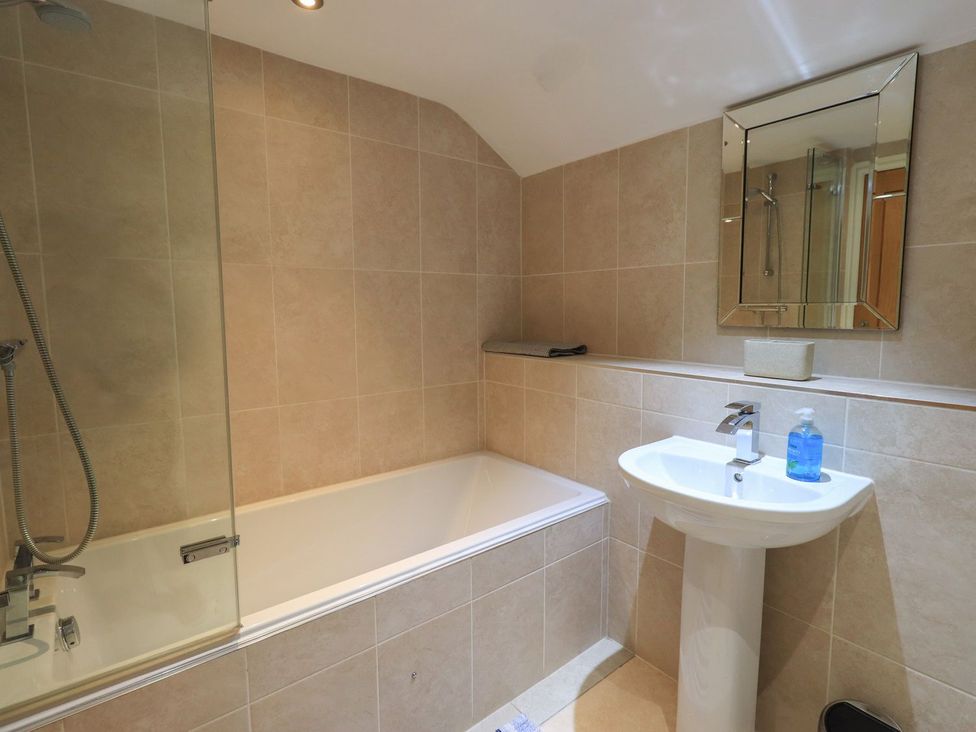 A bathroom with a bathtub and sink at Orcaber Farm Barn in Lancaster