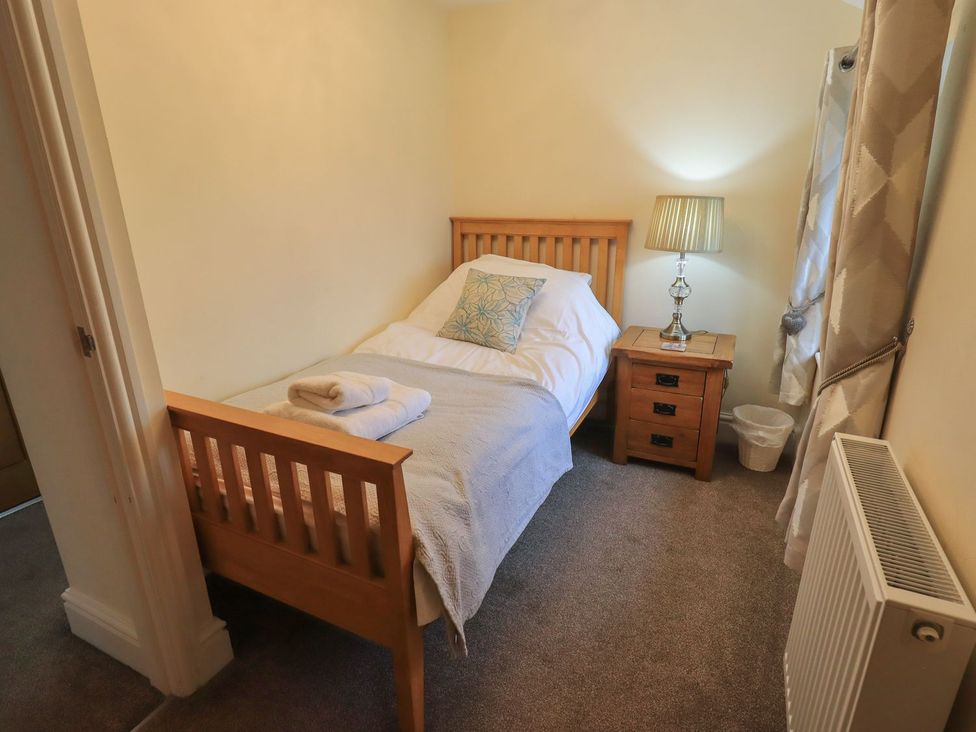 A bedroom with a single bed and nightstand at Orcaber Farm Barn in Lancaster