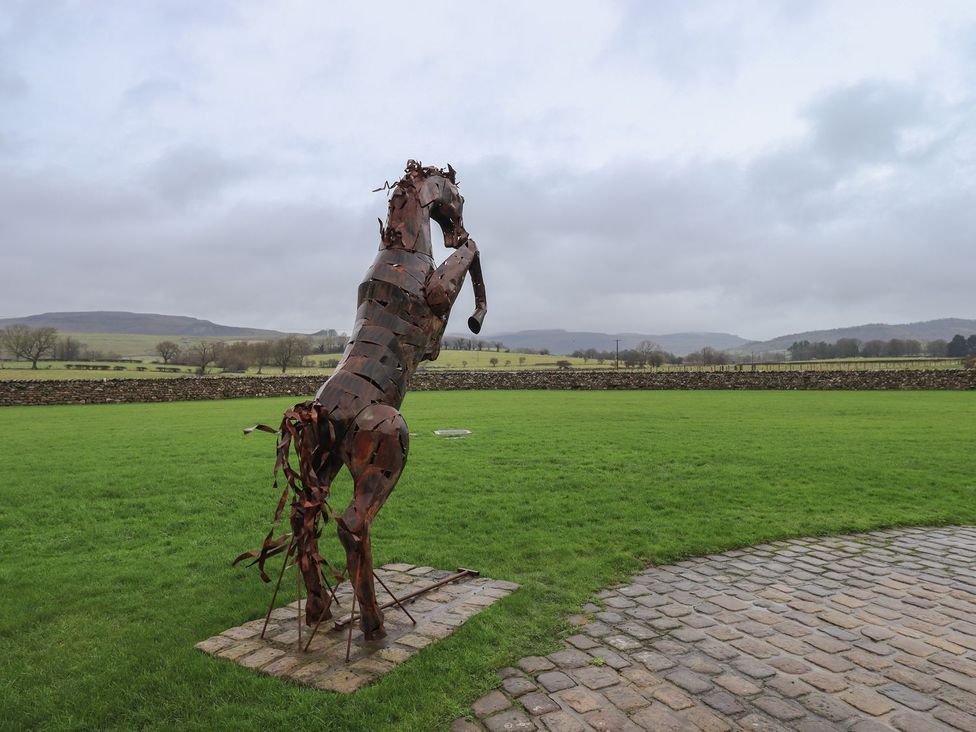 A horse sculpture in a grassy area at Orcaber Farm Barn Lancaster