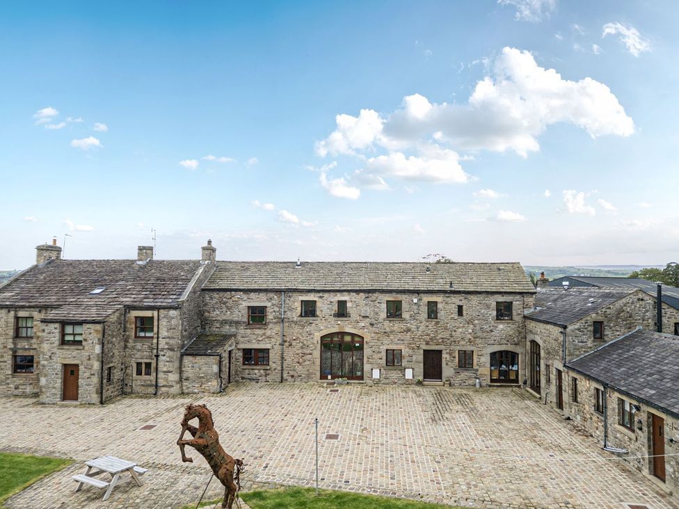 A stone building complex in a courtyard at Orcaber Farm Barn Lancaster