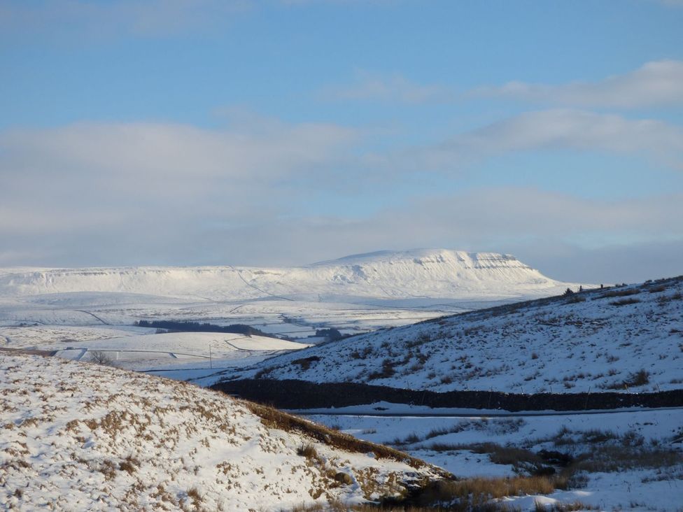 A snowy landscape with hills and a mountain at Orcaber Farm Barn, Lancaster