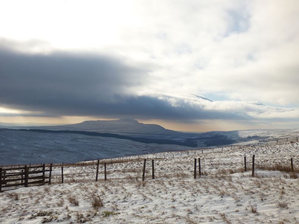 A snowy landscape with mountains and a fence at Orcaber Farm Barn in Lancaster