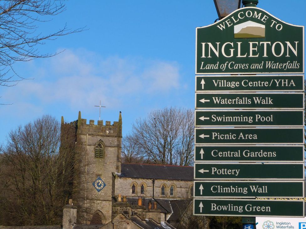 A welcome sign to Ingleton with directions near a church at Orcaber Farm Barn Lancaster