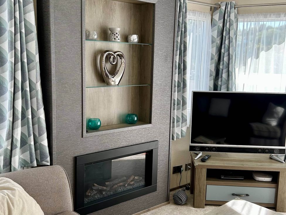 A living room with a fireplace and television at Static Caravan Mallard Rise 22 Hoburne Devon Bay, Paignton